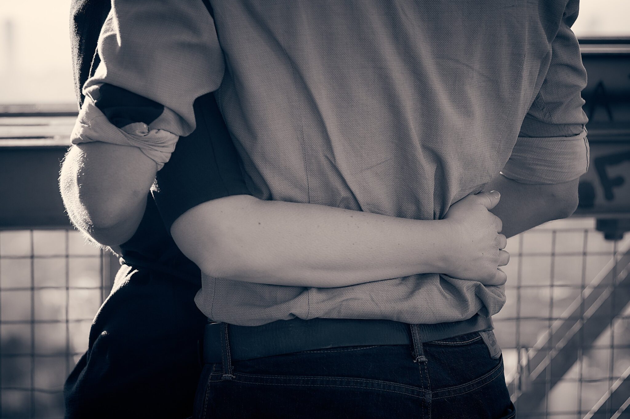 Primer plano en blanco y negro de una pareja abrazándose fuertemente por la cintura