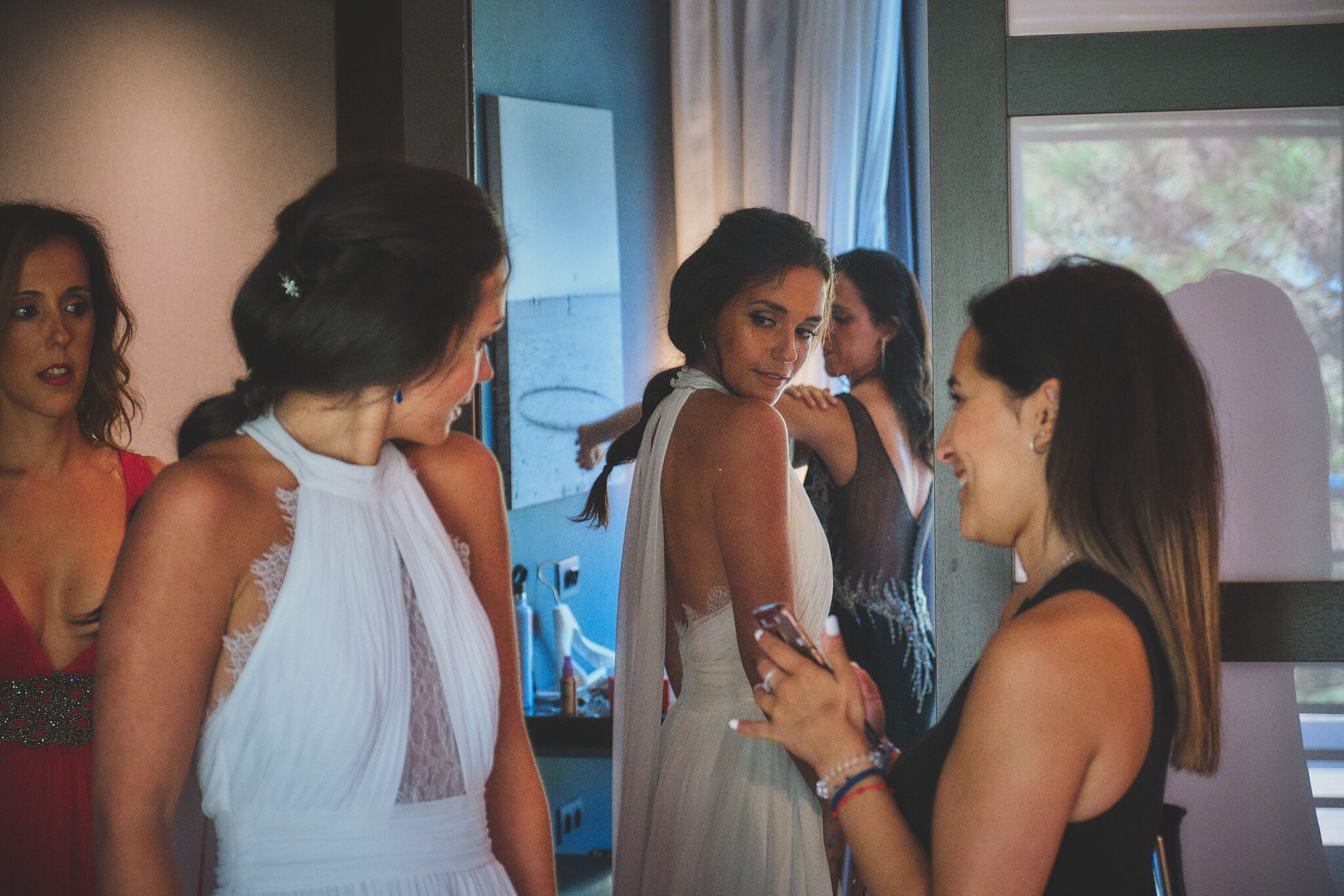 Fotoperiodismo de bodas capturando las miradas de la novia y sus amigas con luz natural.
